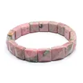 Close-up of natural pink rhodonite stone bracelet with faceted square beads on white background - Rhodonite