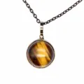 Close-up detail of a vintage round tiger's eye stone pendant necklace on a bronze chain. - Tiger's Eye