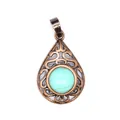 Close-up of teardrop turquoise stone pendant with antique copper hollow filigree - Turquoise