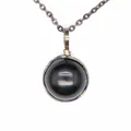 Macro detail of a vintage style necklace with a smooth round black onyx stone pendant - Obsidian