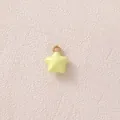 Detail eines kleinen gelben Sternanhängers mit vergoldetem Ring für DIY-Schmuckherstellung - Gelber Stern