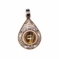 Close-up of vintage hollow teardrop pendant with round tiger eye gemstone detail - Tiger's Eye