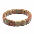 Macro shot of natural green and red Unakite stone square beads on a stretch bracelet - Unakite