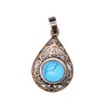 Macro detail of antique copper filigree pendant with turquoise stone inlay. - Blue Turquoise