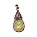 Detailed macro view of retro teardrop pendant featuring green and pink natural stone inlay - Unakite