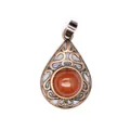 Close-up of a vintage bronze hollow-out teardrop pendant with a red aventurine stone center - Red Jasper