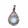 Close-up of vintage hollow teardrop pendant with light blue gemstone in antique bronze finish - Opal