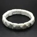 Close-up detail showing the white marble texture of faceted square stone beads. - Howlite