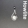 Elegant silver-toned teardrop pendant featuring a round white howlite stone and clear accents - Howlite