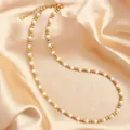 Detailed macro view of gold steel beads and imitation pearls on a satin background - Gold White 4mm