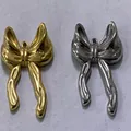 Macro-weergave van gouden en zilveren roestvrijstalen strikhangers voor DIY-sieraden. - 21.5x22.25x4.44mm (Gat 1.87mm)