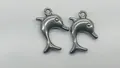 Detailansicht von zwei polierten silbernen Delfin-Anhängern für DIY-Handwerksschmuck - 19.7*15.45*3.35mm