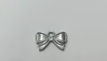 Detailweergave van een zilverkleurige roestvrijstalen strikvormige hanger - Strik Hanger (HY-674) / 18.8x12.2x1.5mm (Gat 2.95mm) / Staalkleur
