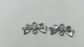 Close-up van roestvrijstalen strikhangers voor DIY-sieraden maken en knutselen projecten - Strik Hanger (HY-669) / 16.8x8.5x1.8mm (Gat 1.9mm) / Staalkleur