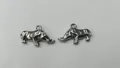 Close-up view of two polished silver stainless steel rhinoceros charms for DIY jewelry - 23.45x14.35x3.85mm