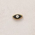 Detail macro of gold-plated stainless steel evil eye bead with black oil dripping. - Evil Eye / Black