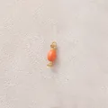 Close-up detail of an orange candy-shaped oil-dripping jewelry pendant component for DIY - Candy / Orange Candy
