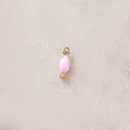 Detail view of a pink candy-shaped dripping oil pendant with gold-plated ring. - Pink Candy