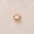 Gros plan d'une perle patte de chat en émail rose et acier inoxydable doré pour bijoux DIY. - Patte Rose