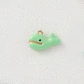 Macro view of a light green enamel whale charm with elegant gold-colored metal edges - Green Whale