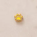 Vue détaillée d'une perle breloque patte dorée avec un remplissage en émail jaune. - Patte Jaune