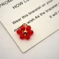 Detailed macro view of a red crystal flower charm with gold-plated stainless steel finish - 13mmx10mmx3.5mm / Red