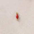 Macro view of a red enamel candy hourglass charm accessory for DIY jewelry making projects. - Red Candy