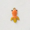 Detailed view of a gold-plated stainless steel fish pendant with vibrant orange enamel coating - Goldfish