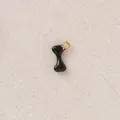 Detailed macro shot of a black enameled bone-shaped charm for DIY jewelry necklace - Black Bone