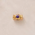 Detailansicht einer vergoldeten Bonbon-Perle mit lila Emaille-Hasen für DIY-Schmuck. - Lila Bonbon