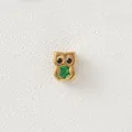 Detailed view of golden owl bead with green enamel belly for DIY jewelry design - Owl