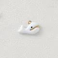Close-up view of a minimalist white enamel whale pendant with gold-plated steel details - White Whale