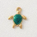 Macro view of a gold-plated stainless steel turtle charm with green enamel shell detail. - Green Turtle