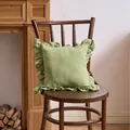 French style ruffled pillowcase in sage green, displayed on a vintage wooden chair - 45x45cm / Pale Green