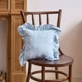 Elegant light blue ruffled decorative pillowcase displayed on a vintage wooden chair - Sky Blue