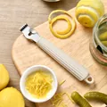Professional stainless steel lemon zester with ergonomic beige handle on cutting board - Cream White
