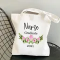 Detailansicht weißer Baumwollbeutel mit Nurse Graduate 2021 Blumendruck - Absolvent 2021 Stil / L