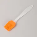 Small orange silicone basting brush with a translucent plastic handle for BBQ and baking - Bulk/Loose Packaging / Orange