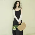Elegant black French style satin slip dress paired with a white cropped knit cardigan - Black