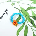 Bohemian style handmade light blue seed bead ring featuring a vibrant orange flower - Light Blue with Orange and Red Flower (Style 4)