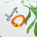 Handmade orange seed bead ring featuring a yellow flower accent, Bohemian jewelry style - Transparent Orange With Flower (Style 12)