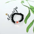 Handmade black beaded ring featuring a delicate clear flower with a vibrant red center - Black With Flower (Style 14)