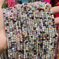 Mano che regge più fili di perline di cristallo naturale sfaccettato multicolore per gioielli - 2mm 180 Pz/Confezione / Cristallo naturale multicolore sfaccettato