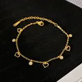 Dettaglio di un bracciale in acciaio al titanio placcato oro con cuori e cristalli - Cuore Traforato (YMB632) / Oro