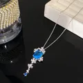Detalle de un collar de plata floral con un colgante de cristal azul rectangular. - Collar Cuadrado Flor Plata-Azul