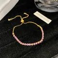 Detail eines verstellbaren goldfarbenen Armbands mit lila Kristallen auf schwarzem Samt - Lavendel