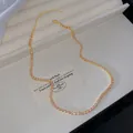Elegant light luxury gold-tone necklace with sparkling pink crystals on a jewelry tray - Light Pink