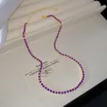 Elegant gold plated necklace featuring a row of vibrant purple round crystal stones - Purple