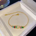 Pulsera dorada con piedras de colores y un colgante con la inicial U de cristal brillante - Letra U