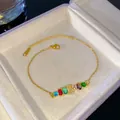 Pulsera de cadena dorada con piedras arcoíris y dije de letra D con pavé en joyero - Letra I